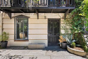 Un edificio con ventana, puerta y balcón con barandilla.