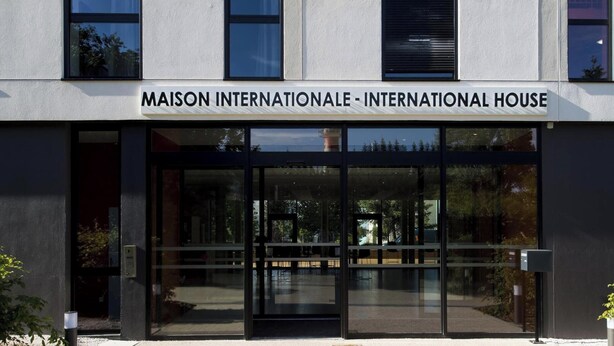 En modern byggnad med en skylt som lyder: ”MAISON INTERNATIONALE – INTERNATIONAL HOUSE”.