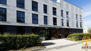 En modern byggnad med en skylt som lyder: ”MAISON INTERNATIONALE – INTERNATIONAL HOUSE”.