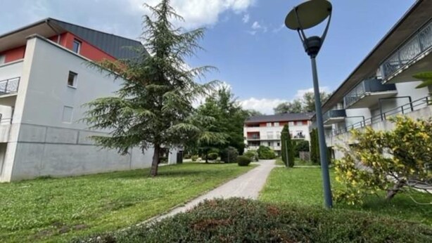 A pathway leading to a building with a red roof and white walls, surrounded by greenery and a street lamp. - Apartment Near Lake Geneva and Mont Blanc (Herbeys)