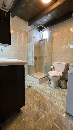 Ein Badezimmer mit Dusche, Toilette und Waschbecken.