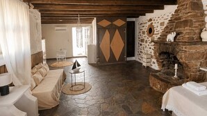 Een rustiek interieur met een stenen openhaard, een zithoek en een eethoek.