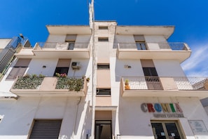 Un edificio de varios pisos con balcones, una entrada visible y un letrero que dice 'CROMIA'.