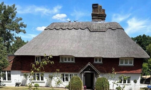 15th century thatched farmhouse in picturesque village surrounded by countryside