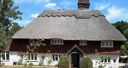15th century thatched farmhouse in picturesque village surrounded by countryside