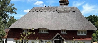 15th century thatched farmhouse in picturesque village surrounded by countryside