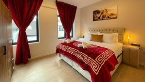 Una camera d'albergo con un letto, un comodino, una lampada e un quadro appeso al muro.