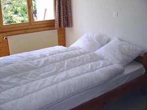 A single bed with white bedding in a room with wooden walls and a window. - 3-room apartment for 4 persons : Living room - kitchen with dishwasher and filtercoffeemachine- 1 ro (Grimentz)
