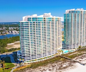 A high-rise hotel with multiple floors, a pool, and a beach view. - Turquoise Place 2401C by Liquid Life (Orange Beach)