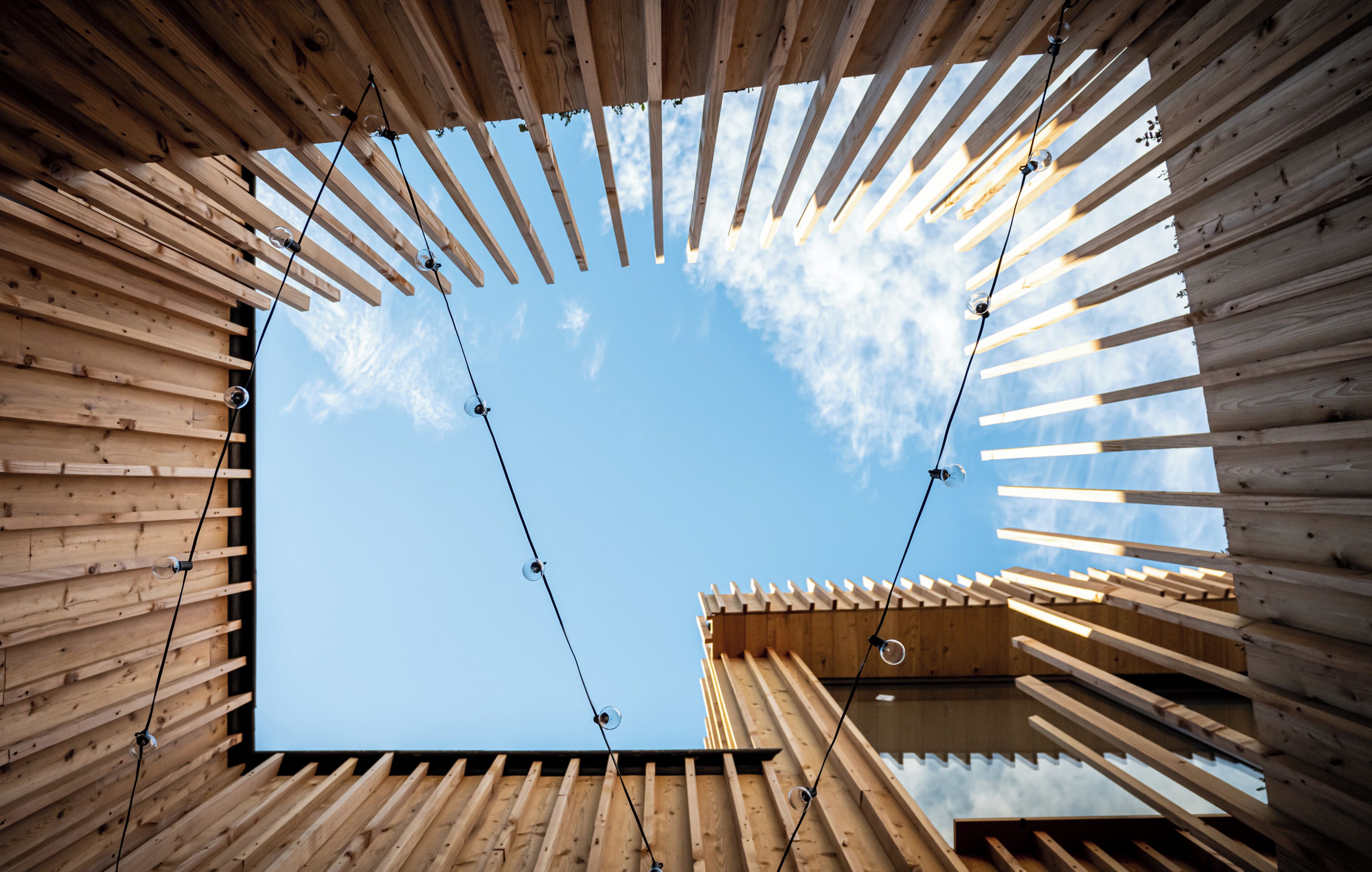 Une structure en bois offrant une vue dégagée sur le ciel à travers une ouverture circulaire.