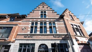 A brick building with a sign reading "The Witch" at the ground level.