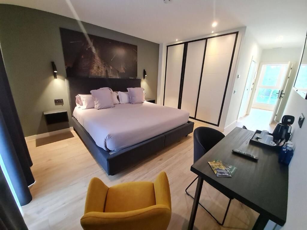 Una camera da letto moderna con un letto, una scrivania, una sedia e un armadio.