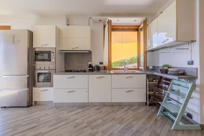 Eine moderne Küche mit Einbauofen, Mikrowelle und Edelstahlkühlschrank.