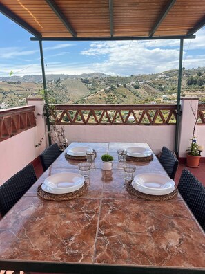 Mesa posta para quatro com vista para uma paisagem montanhosa.