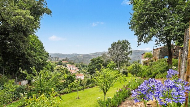 A lush garden with a variety of trees and a stone building. - Cantinho do Préstimo (Préstimo)