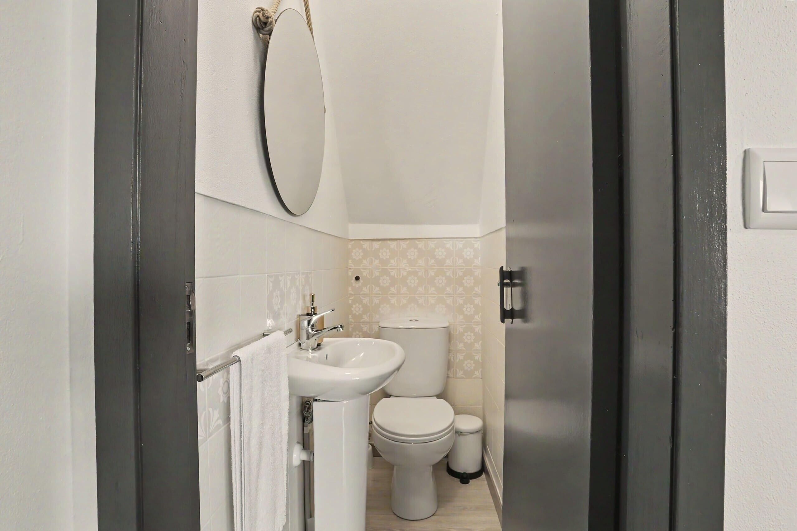 Un baño con inodoro, lavamanos y espejo.