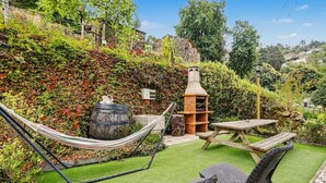 A garden with a hammock, picnic table, and outdoor seating. - Cantinho do Préstimo (Préstimo)