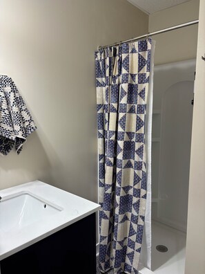 A bathroom with a shower curtain, a sink, and a towel rack. - Brand X Loft Spacious 2 Bedroom Loft in the Heart of Hebron (Hebron)