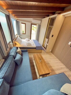 A modern bedroom with a bed, a sofa, a wooden coffee table, and a wardrobe. - Apartment Vagia Nea Smyrni (Nea Smirni)
