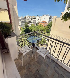 A balcony with a round table and two chairs, overlooking a residential area with multiple buildings. - Apartment Vagia Nea Smyrni (Nea Smirni)