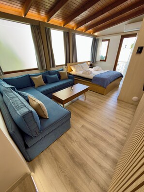 A modern room with a sofa, a bed, a wooden floor, and large windows. - Apartment Vagia Nea Smyrni (Nea Smirni)
