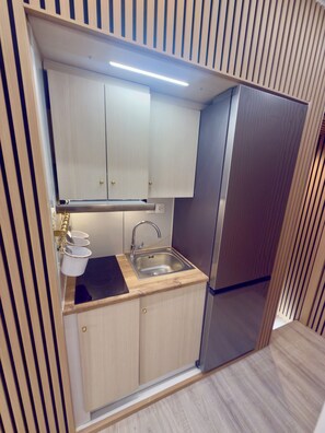 A compact kitchen with a sink, a stainless steel refrigerator, and light-colored cabinetry. - Apartment Vagia Nea Smyrni (Nea Smirni)