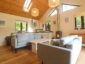 Ein modernes Interieur mit Holzboden, einer Couch, einem Tisch und einem Kamin.