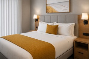 Ein Hotelzimmer mit einem Bett, zwei Nachttischen, einer Kopfteil und einem Wandleuchter, sowie einem Bild.