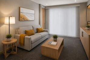Ein modernes Wohnzimmer mit Sofa, Couchtisch, Lampe und Kunstwerken.