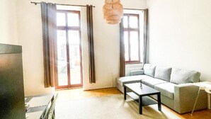 Ein Wohnzimmer mit einer Couch, einem Tisch und einer Pendelleuchte.
