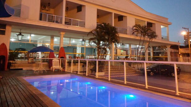A hotel with a swimming pool, outdoor seating, and a two-story structure. - ITER HOTEL  (Rifaina)