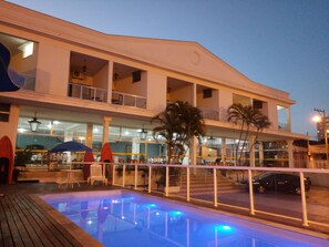 A hotel with a swimming pool, outdoor seating, and a two-story structure. - ITER HOTEL  (Rifaina)