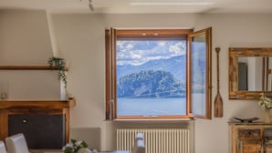 Quarto com uma janela ampla, lareira, radiador, armário de madeira e espelho.