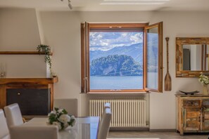 Quarto com uma janela ampla, lareira, radiador, armário de madeira e espelho.