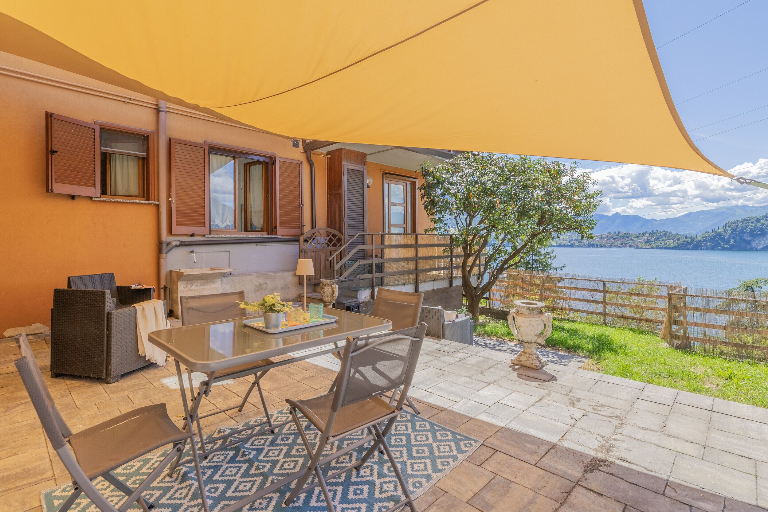 An outdoor patio with a table, chairs, and a large umbrella.