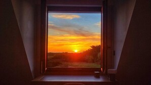 Ein Zimmer mit großem Fenster, einem kleinen Tisch und einem Stuhl.