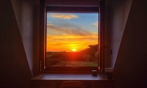 A room with a large window, a small table, and a chair. - Villa Côte Sauvage : quiet, swimming pool and sea view (Quiberon)