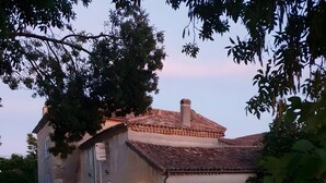 A rustic house with a tiled roof, a chimney, and a gravel driveway. Two cars are parked in front. - Holiday Home Les Quatre Vents with Shared Garden, Terraces, Wi-Fi, and Air Conditioning (Francescas)