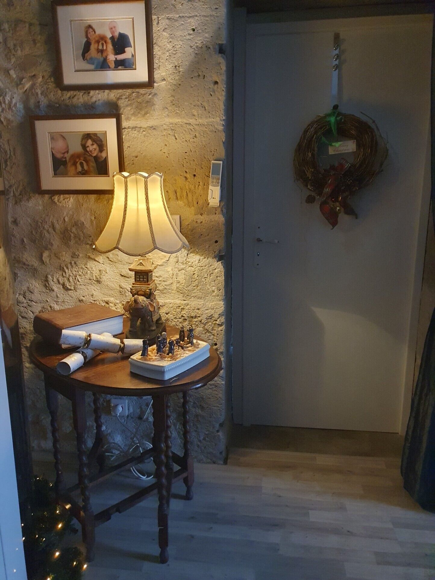 Una stanza con una lampada su un tavolo, una foto incorniciata al muro e una ghirlanda sulla porta.