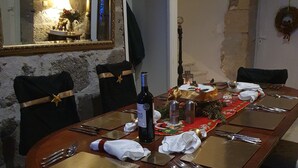A dining table set with chairs, a bottle of wine, and a festive centerpiece. - Holiday Home Les Quatre Vents with Shared Garden, Terraces, Wi-Fi, and Air Conditioning (Francescas)