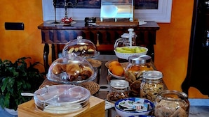 A buffet table with various food items, a painting on the wall, and a candelabra. - Domus Mare Cilento - B&B with pool, sea view and breakfast included (Campania)