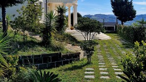 A modern house with a curved facade, a stone pathway, and a well-maintained garden. - Domus Mare Cilento - B&B with pool, sea view and breakfast included (Campania)