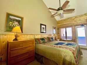A bedroom with a wooden headboard, a bed with a quilt, a ceiling fan, and a window with blinds. - Cabin Feel w/ Loft - Amazing Views -Pool.  Near RMNP, Granby Ranch & Winter Park (Granby)