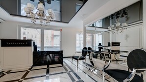 Un hall d’hôtel moderne doté d’un comptoir d’enregistrement, d’un espace salon et de grandes fenêtres.