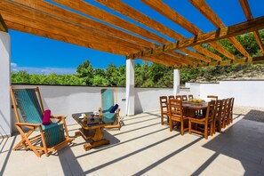 An outdoor patio with wooden furniture, a pergola, and a view of greenery. - Villa Lubey 2 Zadarvillas (Razanac)