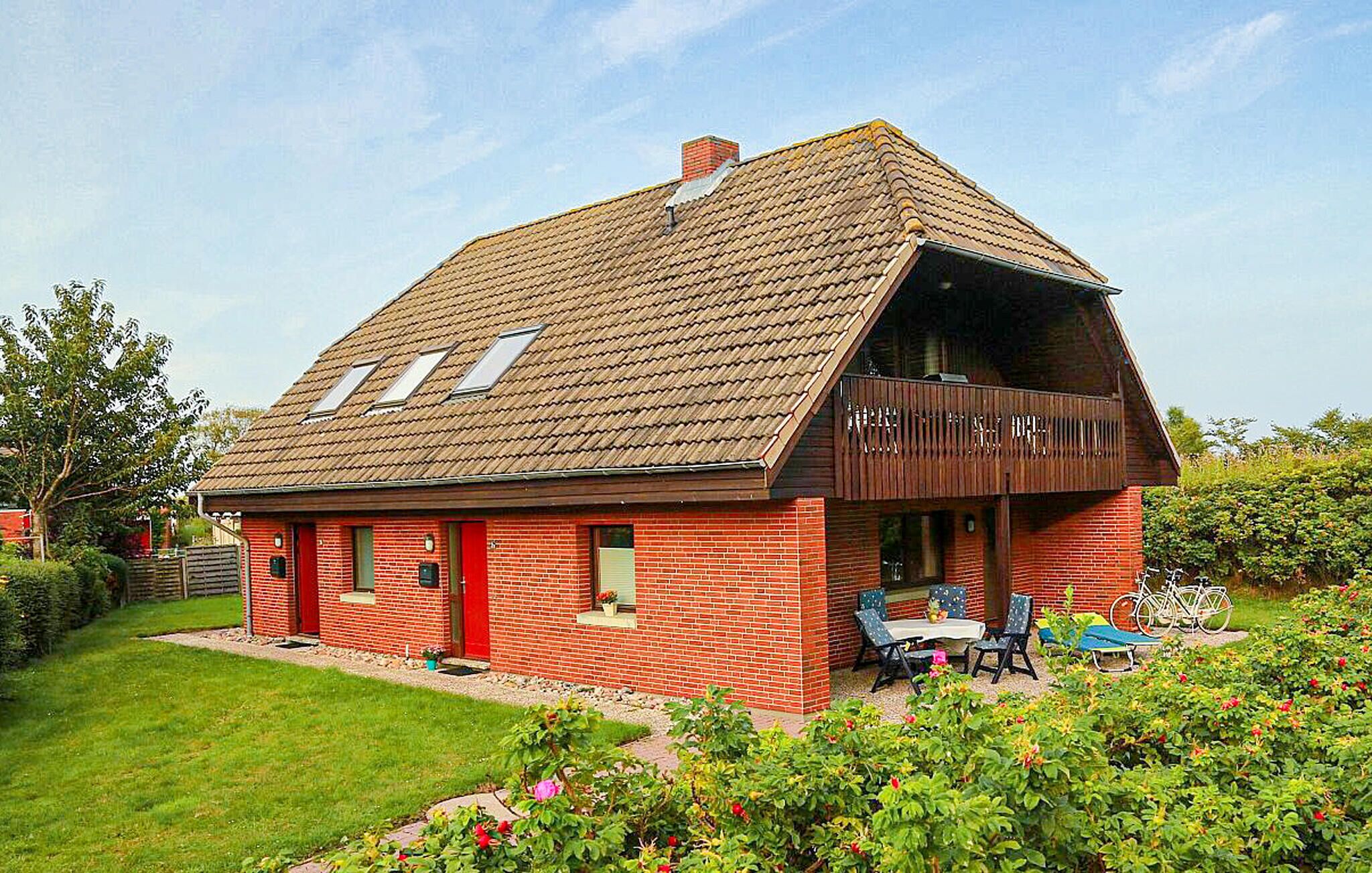 Een rode bakstenen woning met schuin dak en een overdekte veranda.
