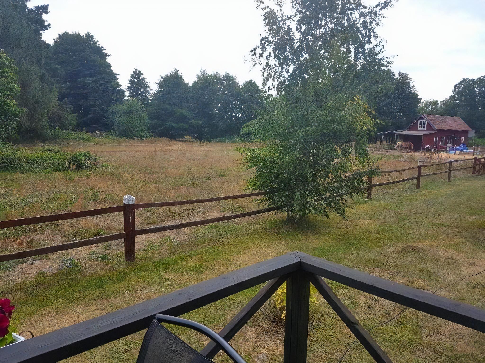 A fenced outdoor area with a wooden deck in the foreground.