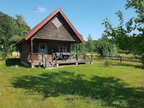 A wooden cabin with a porch, a small table, and a chair. - Cozy holiday home on beautiful Öland. (Löttorp)