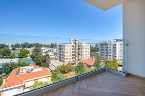 Ein Balkon mit freiem Blick auf umliegende Gebäude und Grünflächen.