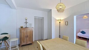 Ein Essbereich mit Tisch, Stühlen, einem Schrank und einer Lampe.